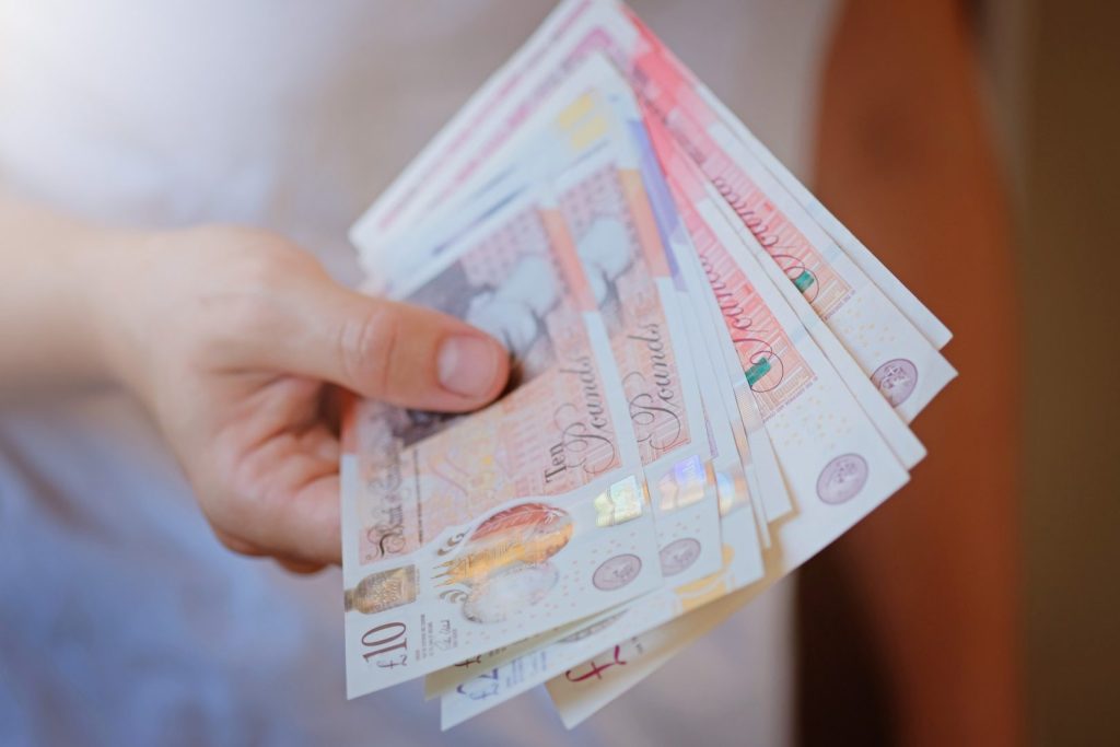 New Plastic Ten and twenty Pound note sterling in woman hands. Crisis and saving concept. British fi